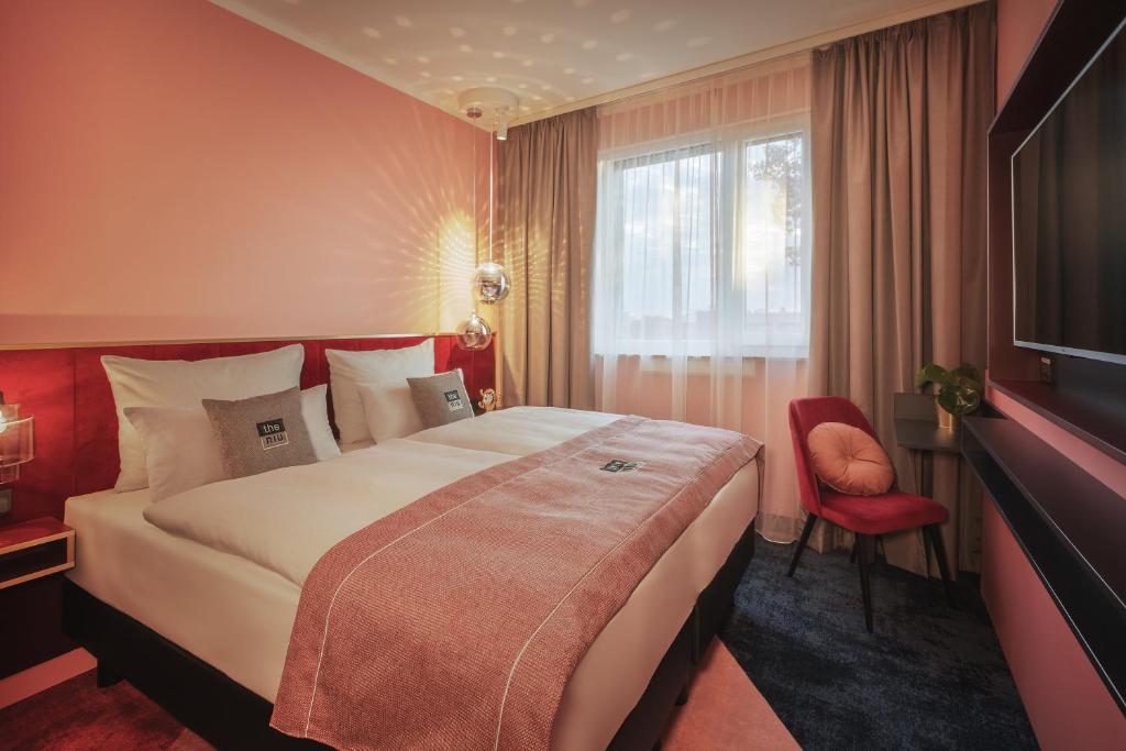 una camera d'albergo con un grande letto e una finestra di the niu Loco a Monaco