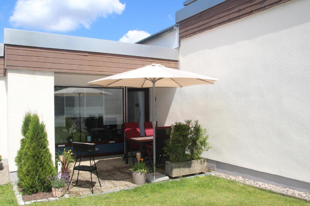 un patio con mesa y sombrilla en Ferienwohnung Raithel, en Bischofsgrün