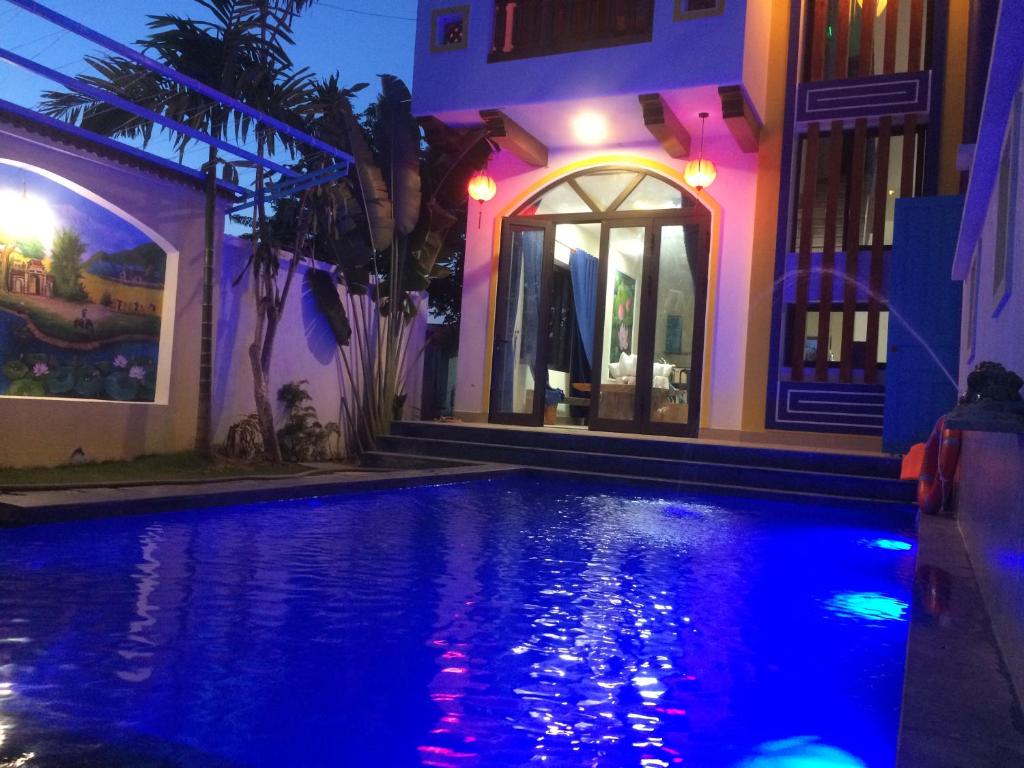 Hồ bơi ngoài trời tại Hoi An Village Villas trở nên ấm cúng khi lên đèn, tạo không gian thư giãn yên bình giữa khuôn viên xanh của Cẩm Thanh.