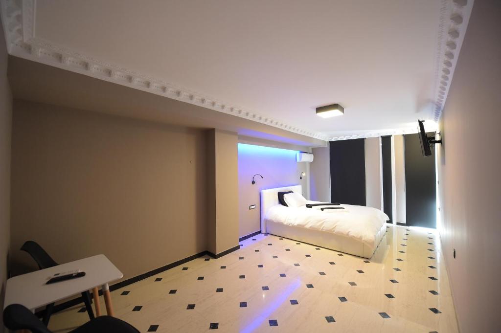 1 dormitorio con cama blanca y luz azul en Pietra Mare Suites en Patras