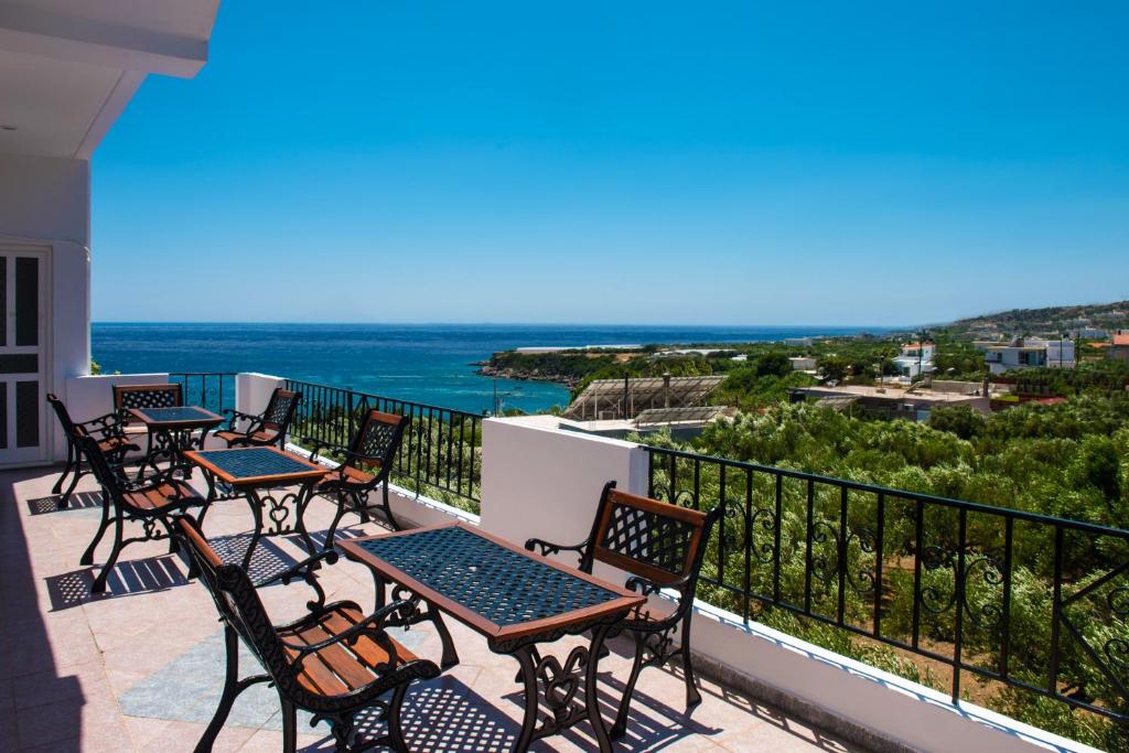 una fila di tavoli e sedie su un balcone con vista sull'oceano di Elena's Beach Garden by Estia a Ferma