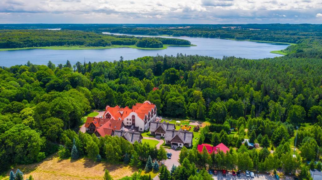 an aerial view of a castle on a hill with a lake at Hotel Aubrecht Country Spa Resort in Przechlewo