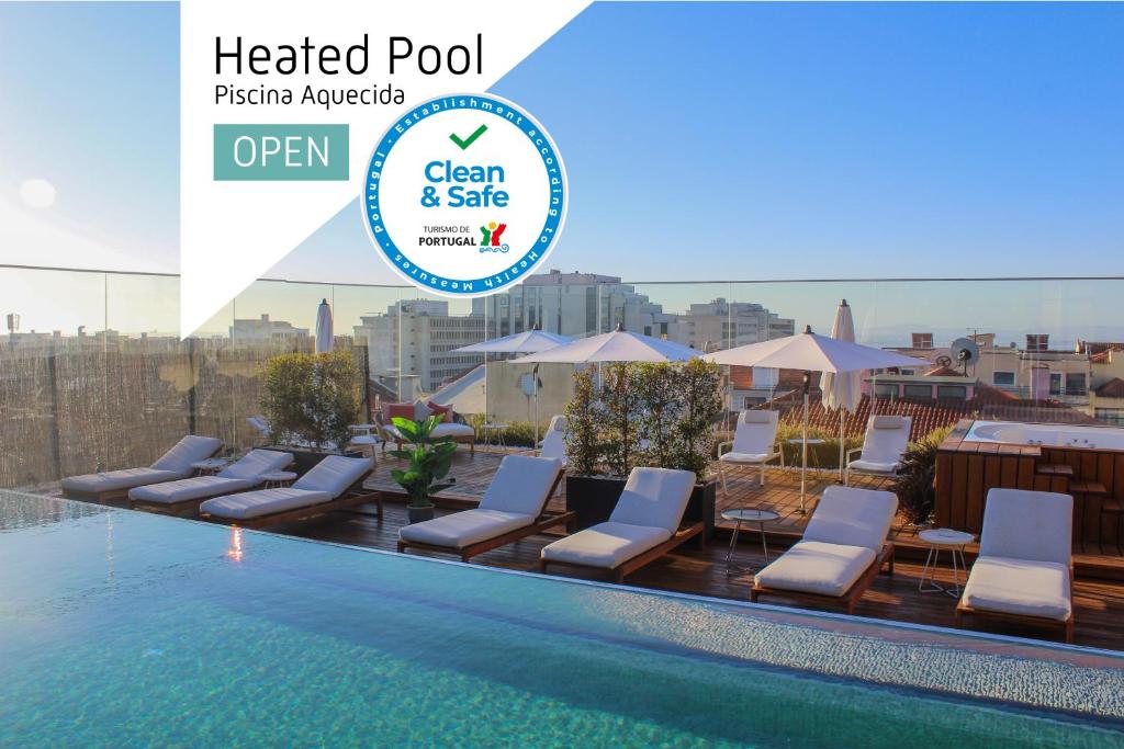 a hotel pool with chairs and umbrellas on a rooftop at Lux Lisboa Park in Lisbon