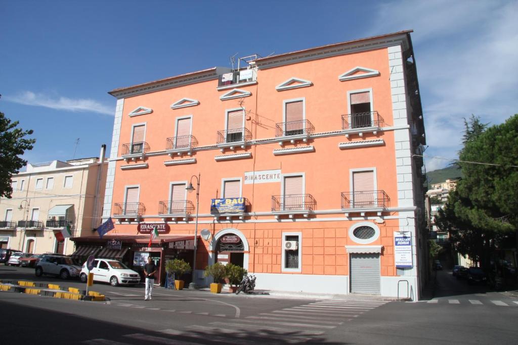 ein großes orangefarbenes Gebäude an einer Stadtstraße in der Unterkunft B&B Rinascente in Paola
