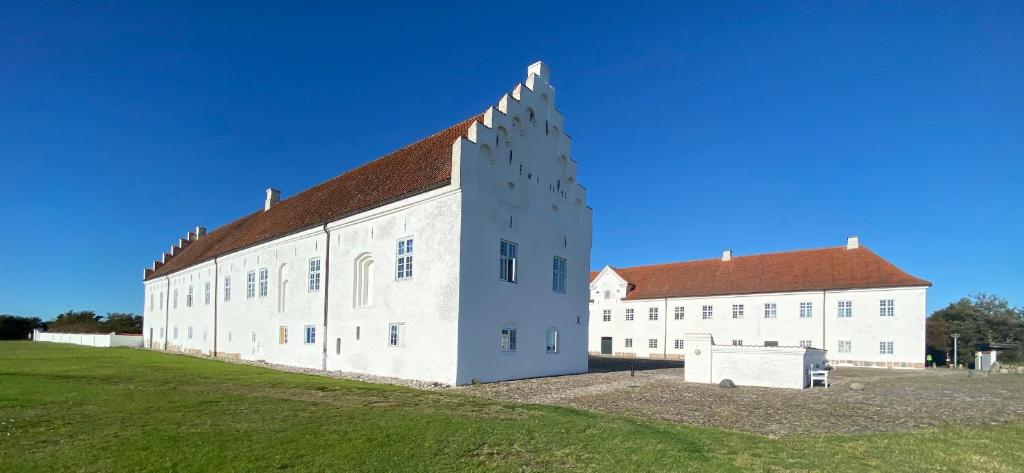 duży biały budynek z czerwonym dachem w obiekcie Danhostel Vitskøl Kloster w mieście Ranum