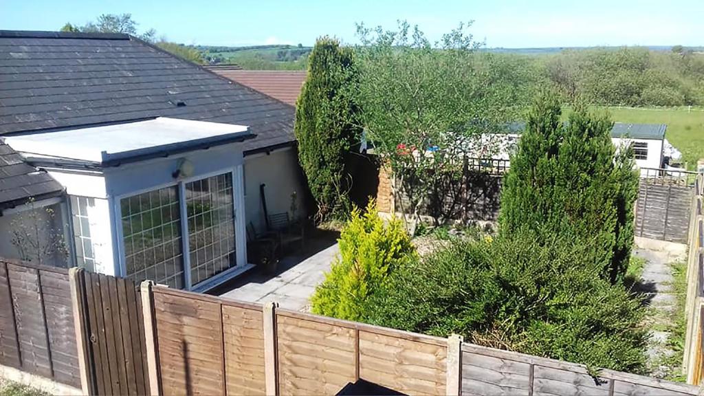 a house with a fence in front of a yard at Edge of Exmoor Garden Flat, dog friendly, sleeps 2 - 4 in East Anstey