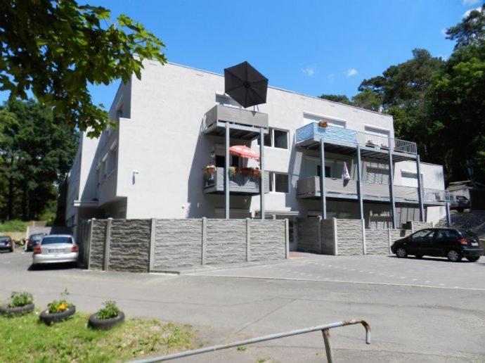 a white building with cars parked in a parking lot at KS GbR Wohnungen in Mechernich