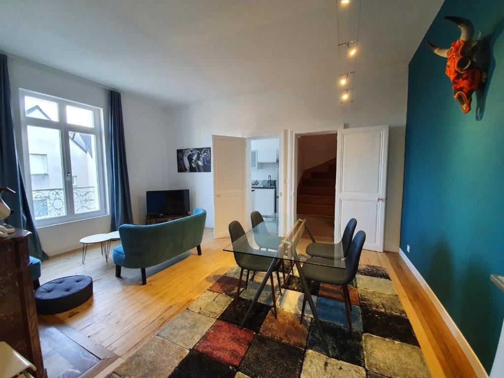 uma sala de estar com uma mesa de vidro e cadeiras em Duplex des montains em Loches