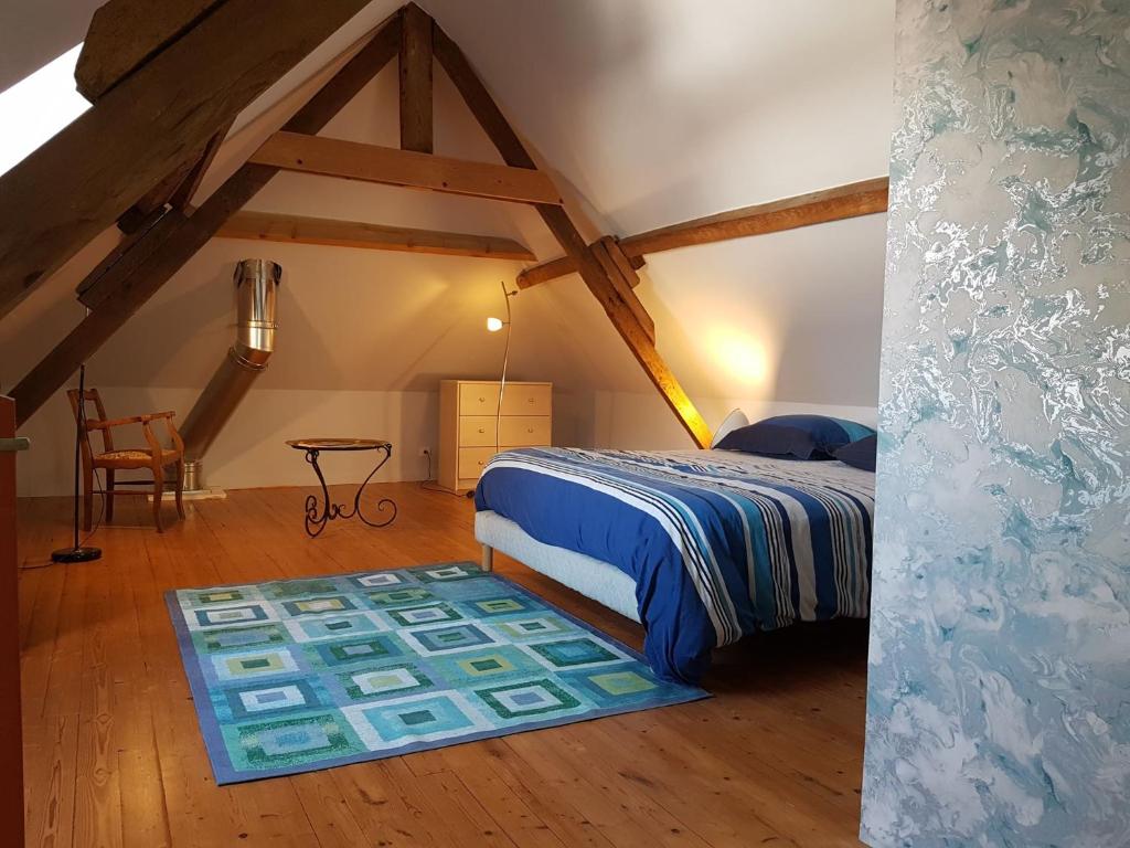 a bedroom with a bed and a table in a attic at spacieuse maison urbaine proche du centre ville in Béthune