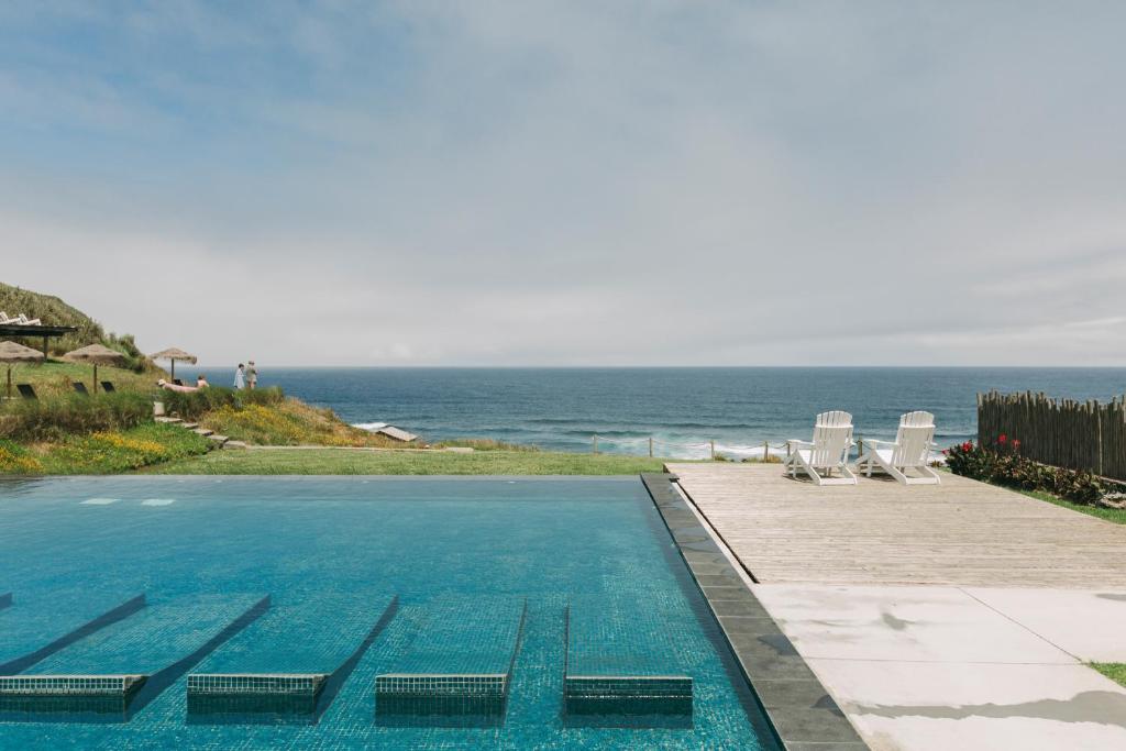 una piscina con vista sull'oceano sullo sfondo di Santa Barbara Eco-Beach Resort a Ribeira Grande