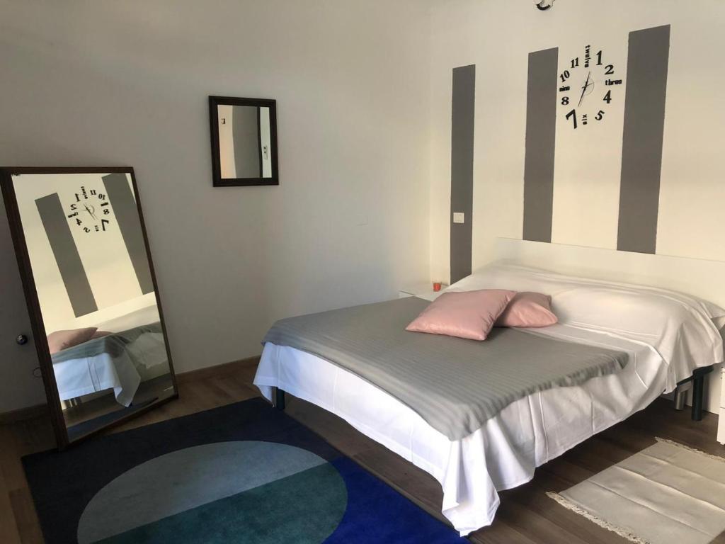 Dormitorio pequeño con cama y espejo en Monolocale arredato con una camera, en Parma