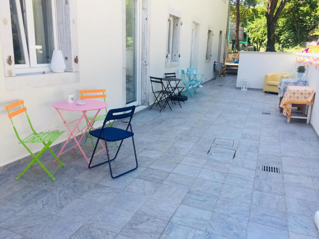 En un edificio hay un patio con mesas y sillas coloridas. en B&B MonteCengio, en Trieste