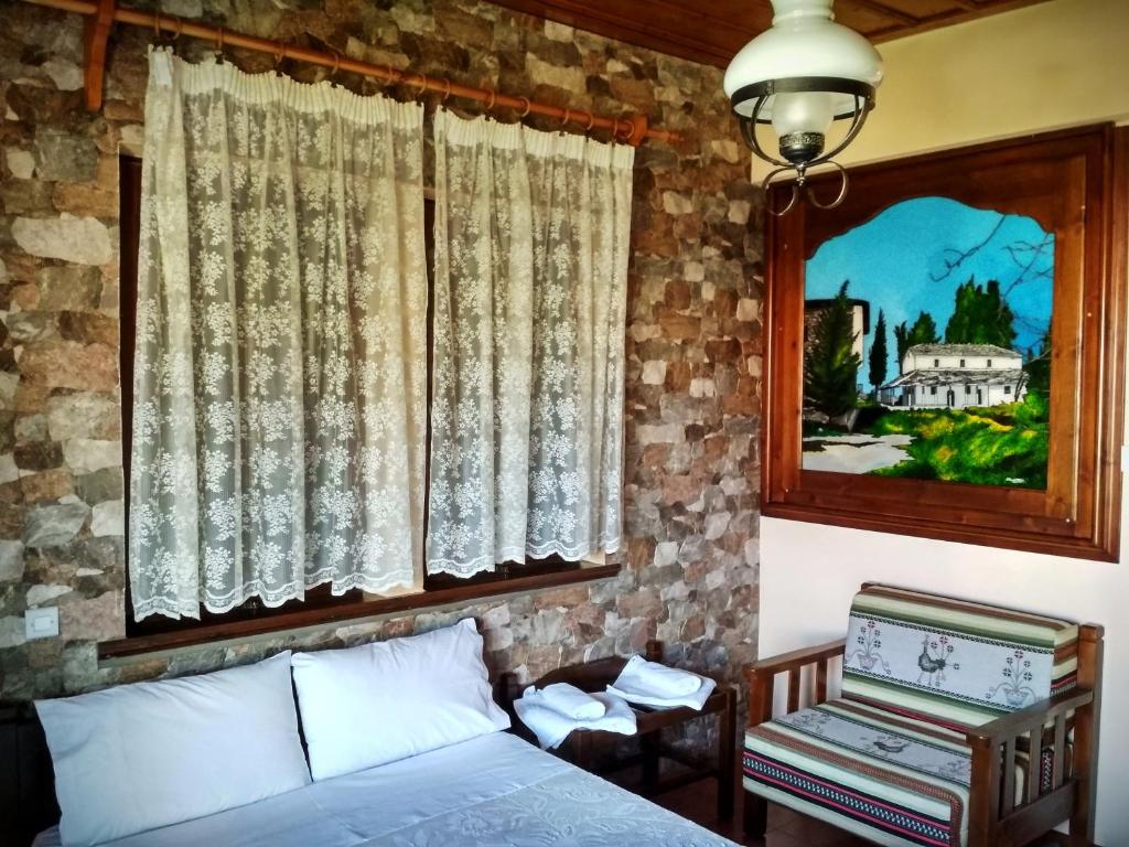 
a bedroom with a bed and a painting on the wall at Christofer's Rooms in Zagora
