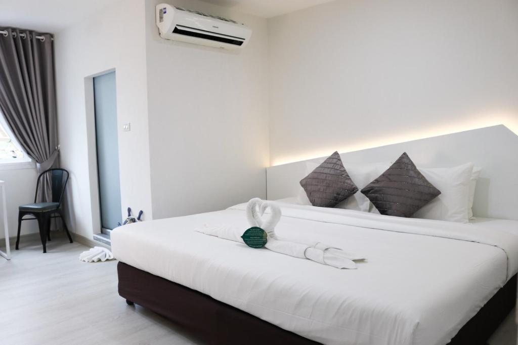 una camera da letto con un grande letto con lenzuola e cuscini bianchi di Bed By Boat @Nonthaburi Pier a Nonthaburi