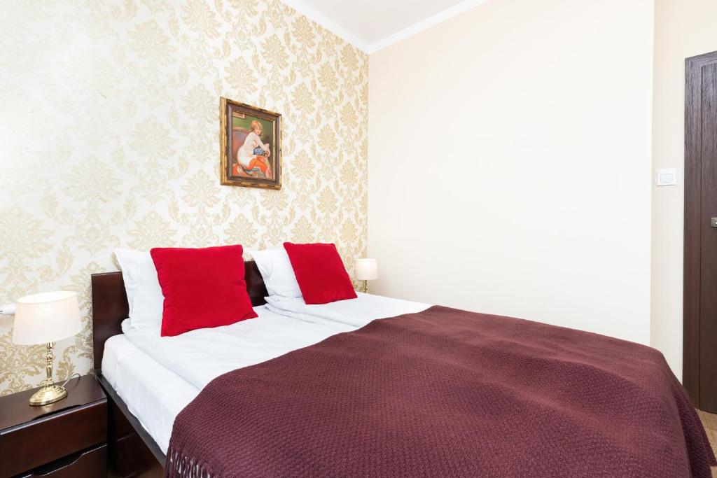 um quarto com uma cama grande e almofadas vermelhas em Apartments Jaglana near Old Town by Renters em Gdansk