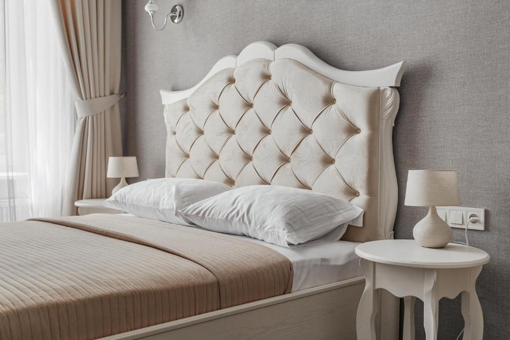 a bedroom with a white bed with a large headboard at Apartments MaisoNº11 in Odesa