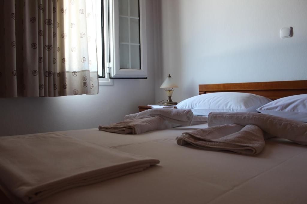 - une chambre avec 2 lits et des serviettes dans l'établissement Koula's Place, à Elafonisos