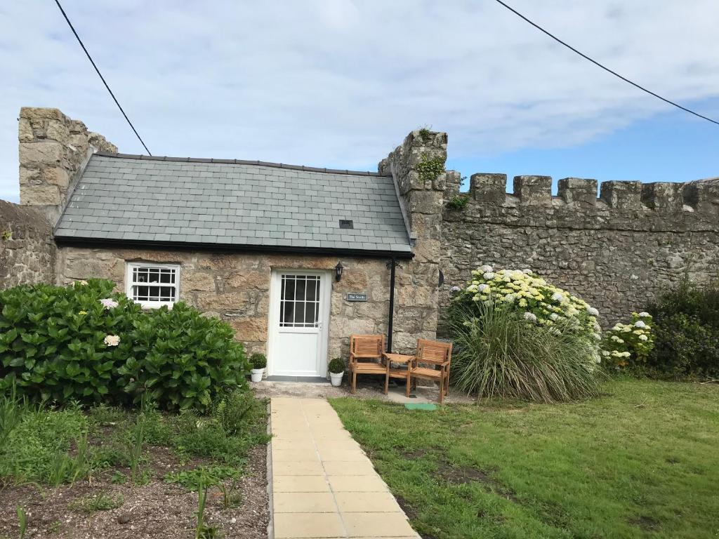 a stone house with a white door and a bench at The Studio @ The Old Vicarage in Pendeen