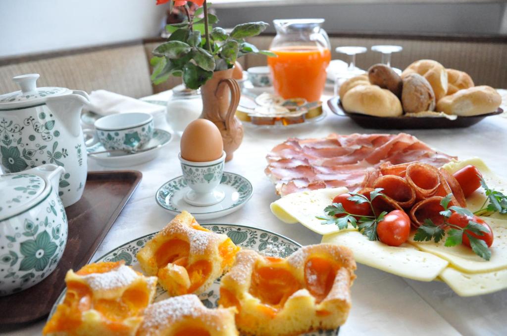 una mesa con platos de comida, huevos y pan en Garni Marianne, en Parcines