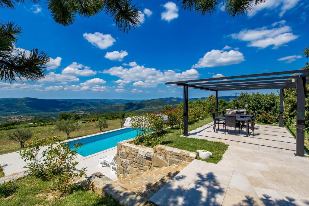 um pátio com uma mesa e vista para as montanhas em Rona Apartment & Rooms Mea Vista em Buzet