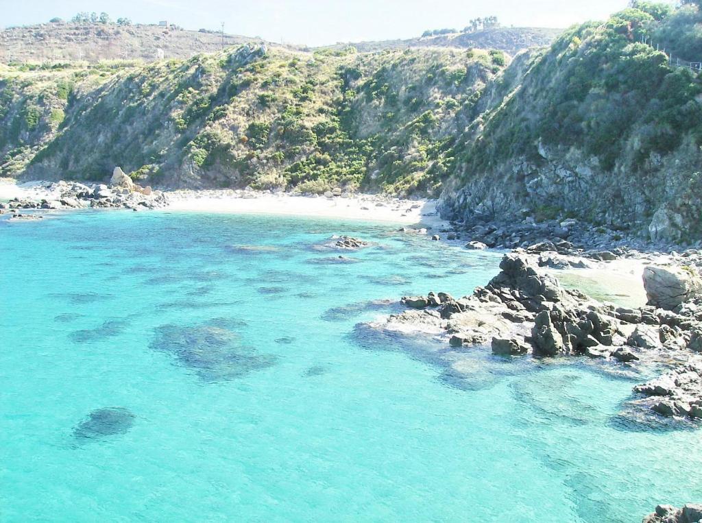 uma vista para uma praia com água azul e rochas em Hotel Residence Riviera Calabra em Zambrone