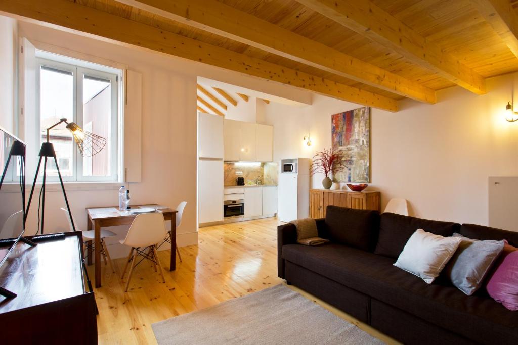 a living room with a couch and a table at APOSENTUS - Clerigos Tower view Mezzanine in Porto