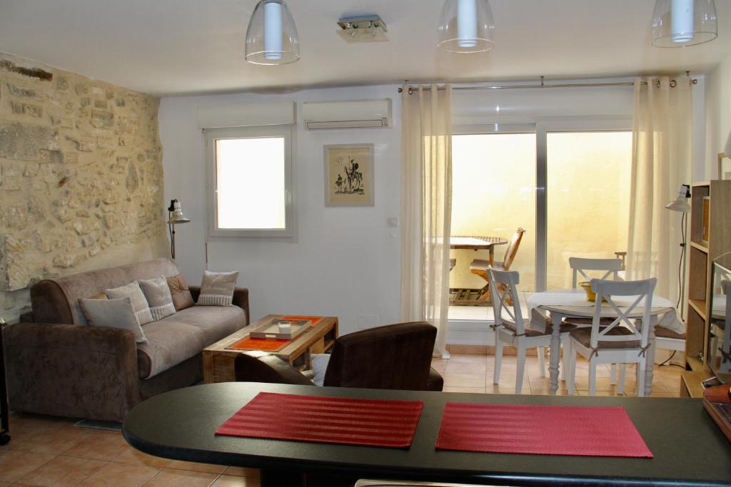 a living room with a couch and a table at Agréable maison de ville in Eyragues