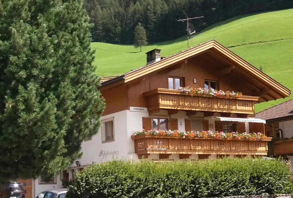 a house with a balcony with flowers on it at Haus Pipperger in Cadipietra