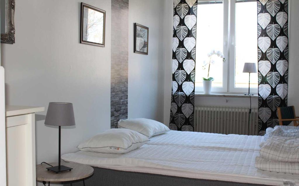 sypialnia z białym łóżkiem i oknem w obiekcie Falköpings Vandrarhem/Hostel w mieście Falköping
