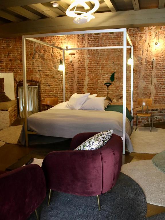 een slaapkamer met een groot bed en 2 stoelen bij De Pelsertoren in Zwolle