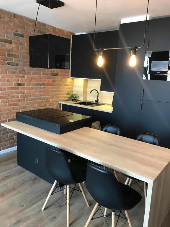 a kitchen with a wooden table and some chairs at SOLE Apartment 2 in Satu Mare