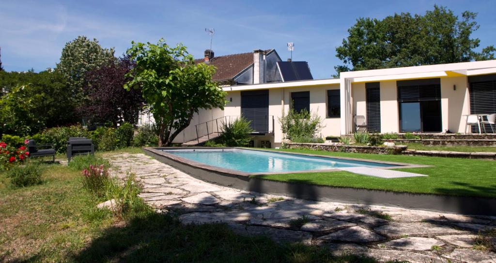 a swimming pool in the yard of a house at Chambre BEAUSEJOUR in Brive-la-Gaillarde