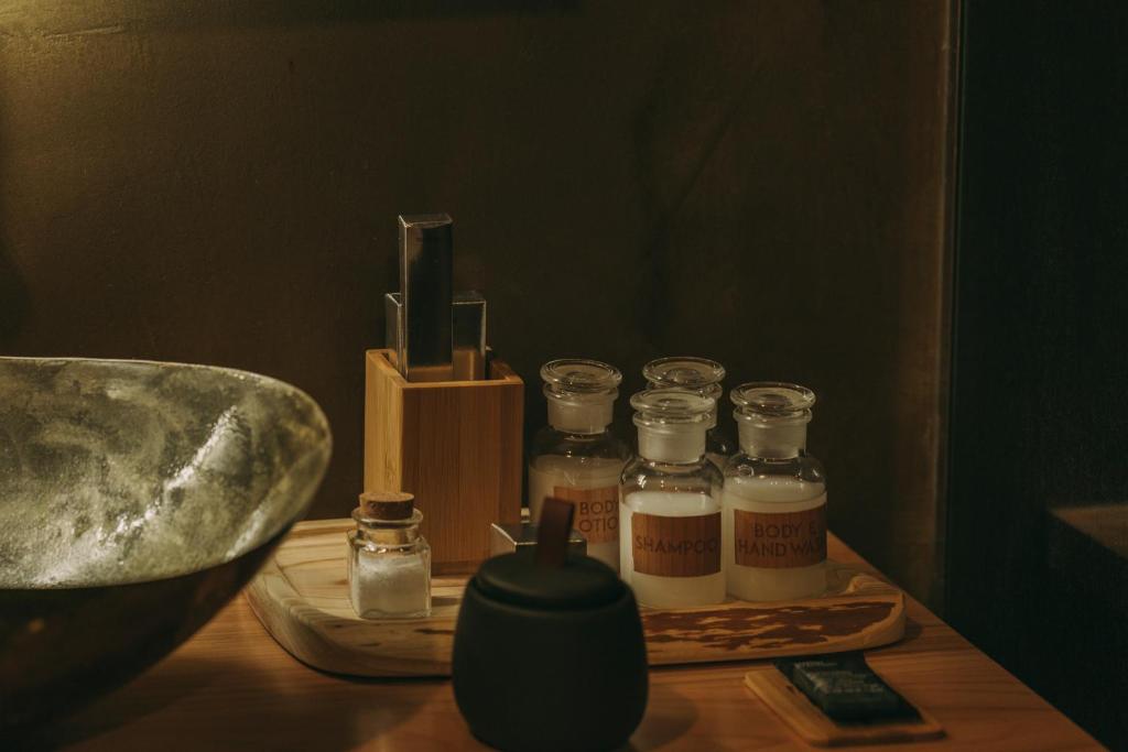 a wooden table with four glass jars and a sink at Santa Barbara Eco-Beach Resort in Ribeira Grande
