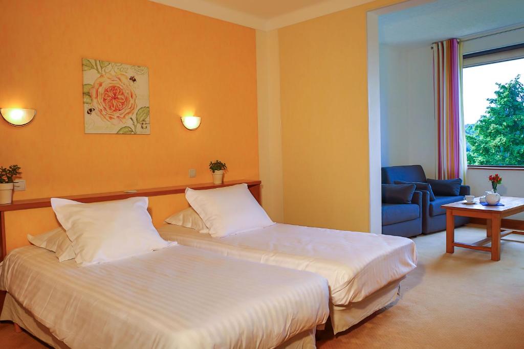 Habitación de hotel con 2 camas y sofá en L'Oustal Del Barry, en Najac