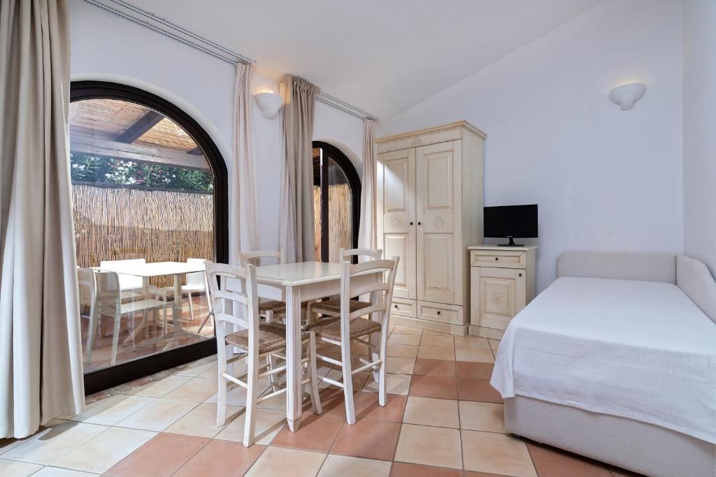 a bedroom with a bed and a table and chairs at Porto Giunco Residence in Villasimius
