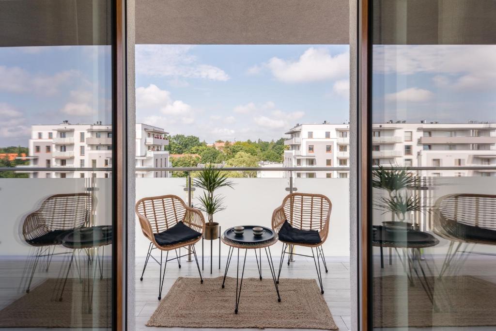 a balcony with chairs and a table on a balcony at Apartament Przystań Calamo in Olsztyn