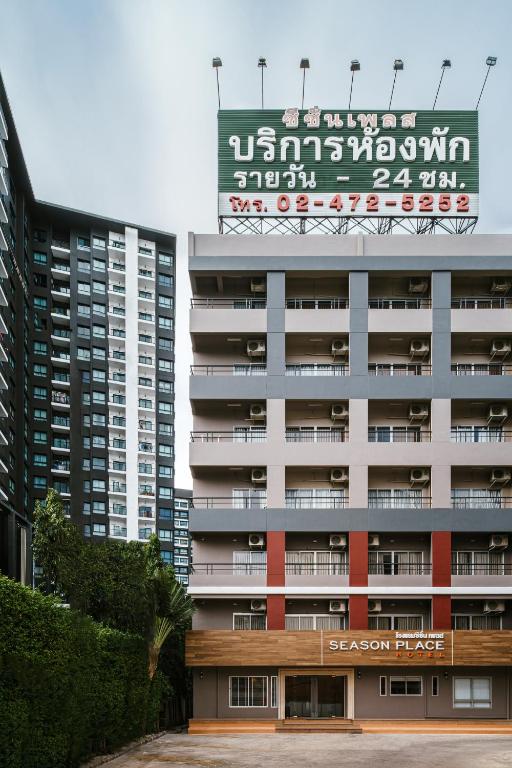 a large building with a sign on top of it at Season Place in Bangkok