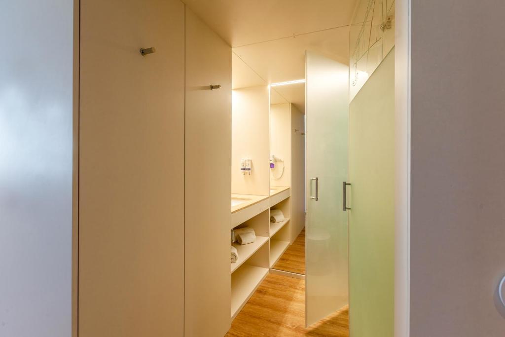 a small bathroom with white walls and a mirror at Sea Porto Hotel in Matosinhos