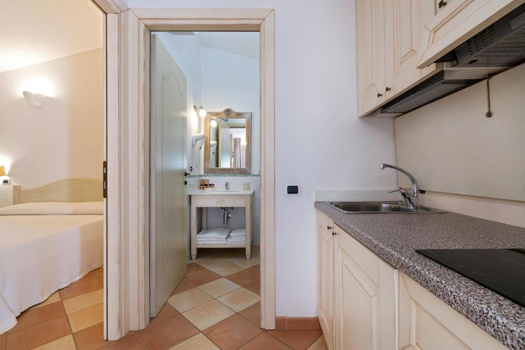 a kitchen with a sink and a bathroom with a tub at Porto Giunco Residence in Villasimius