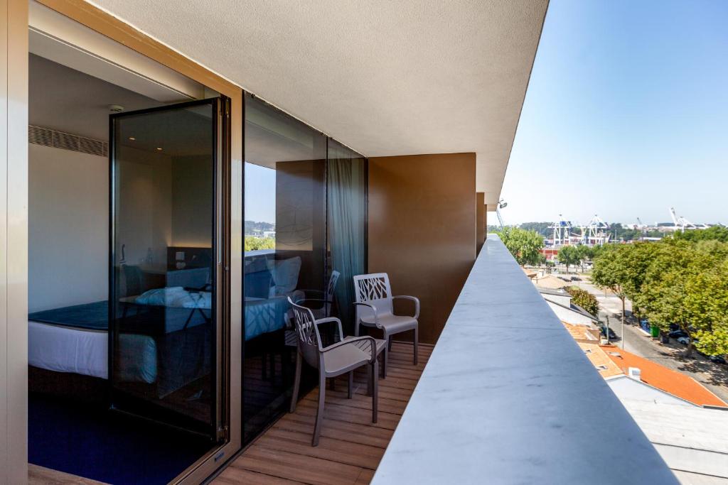 a balcony with a bedroom and a bed at Sea Porto Hotel in Matosinhos