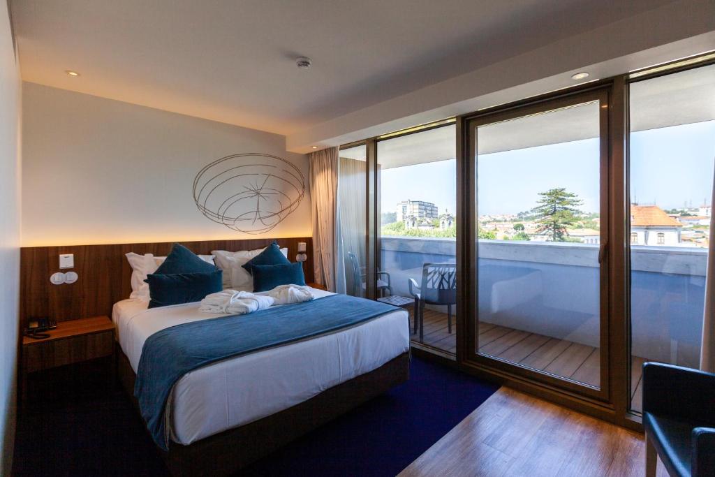 a hotel room with a bed and a balcony at Sea Porto Hotel in Matosinhos