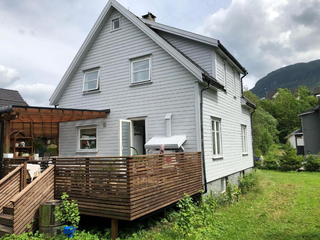 a house with a large wooden deck in front of it at Bed and breakfast in Sauda