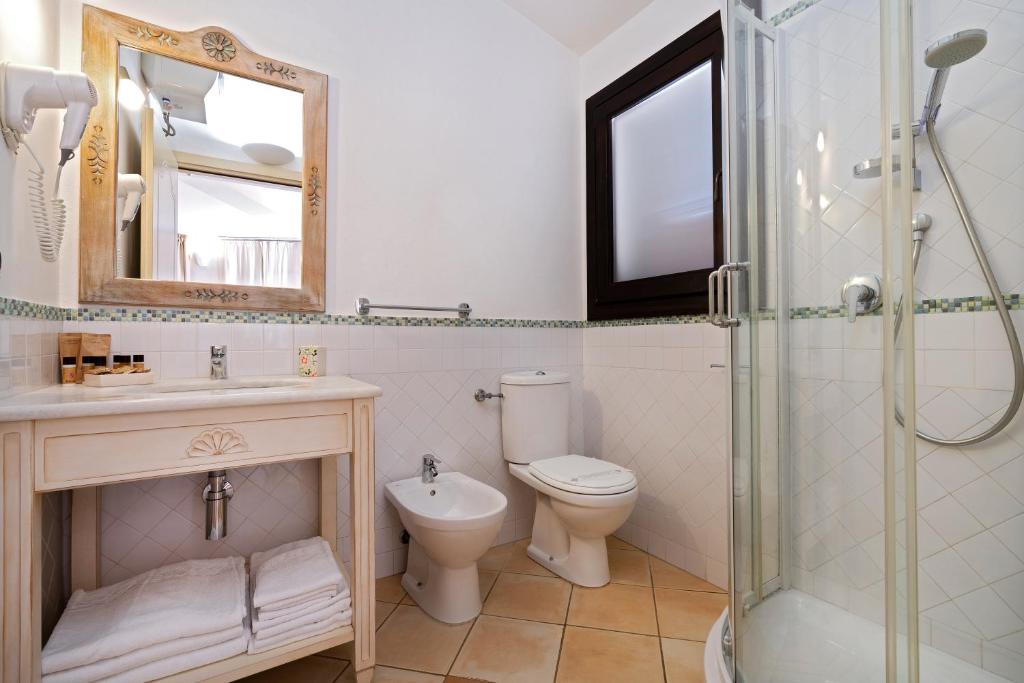 a bathroom with a toilet and a sink and a shower at Porto Giunco Residence in Villasimius