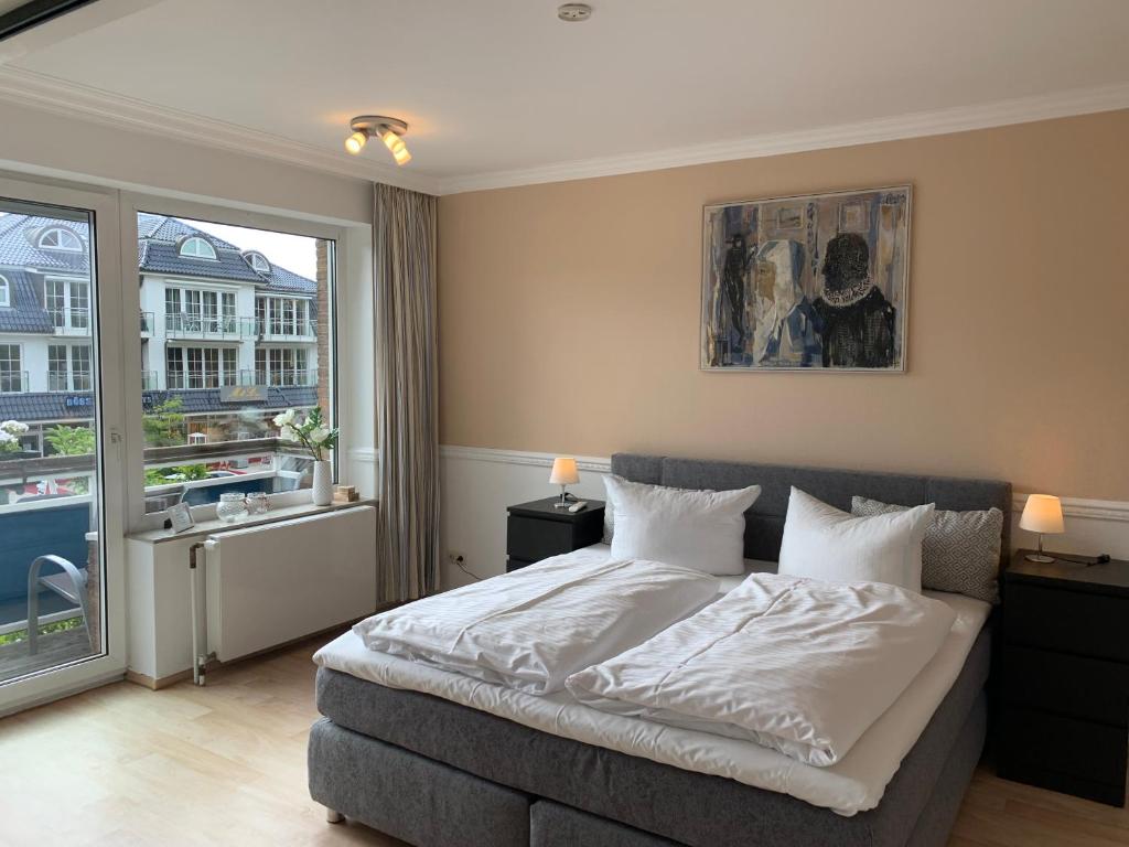 a bedroom with a bed and a large window at Ostseehaus Dreesen in Timmendorfer Strand