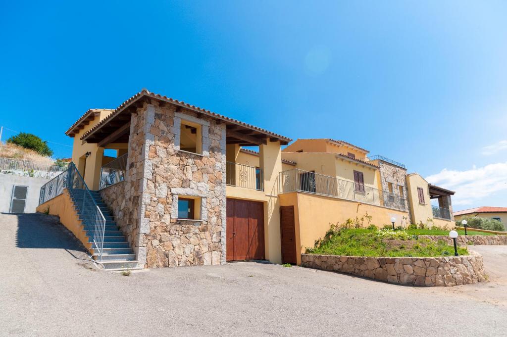 une grande maison avec un garage et une allée dans l'établissement Corte di Gallura, à Budoni