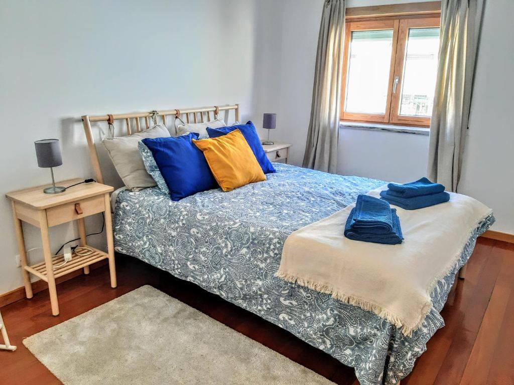 a bedroom with a bed with blue and yellow pillows at Cardeal´s Nest in Lisbon