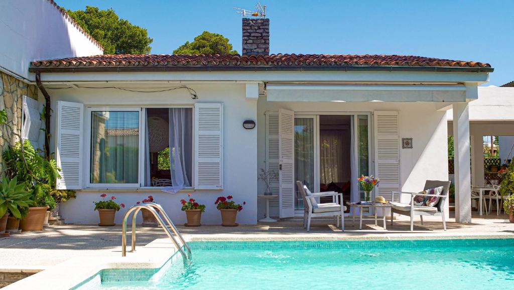 a house with a swimming pool in front of a house at Es Norai 18 in Cala Ratjada