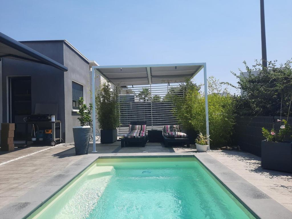 a swimming pool in the middle of a backyard at CHAMBRE COSY Adults only in Agde
