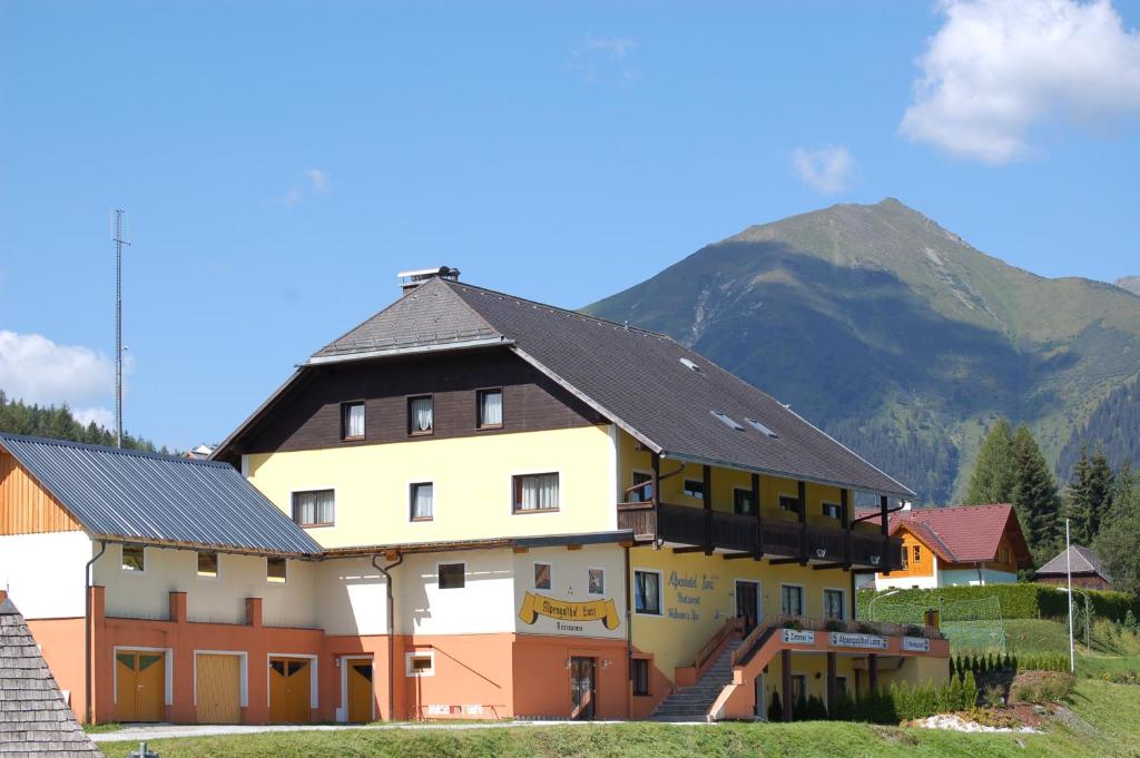 un grand bâtiment avec une montagne en arrière-plan dans l'établissement Alpenhotel & Aparthotel Lanz, à Hohentauern