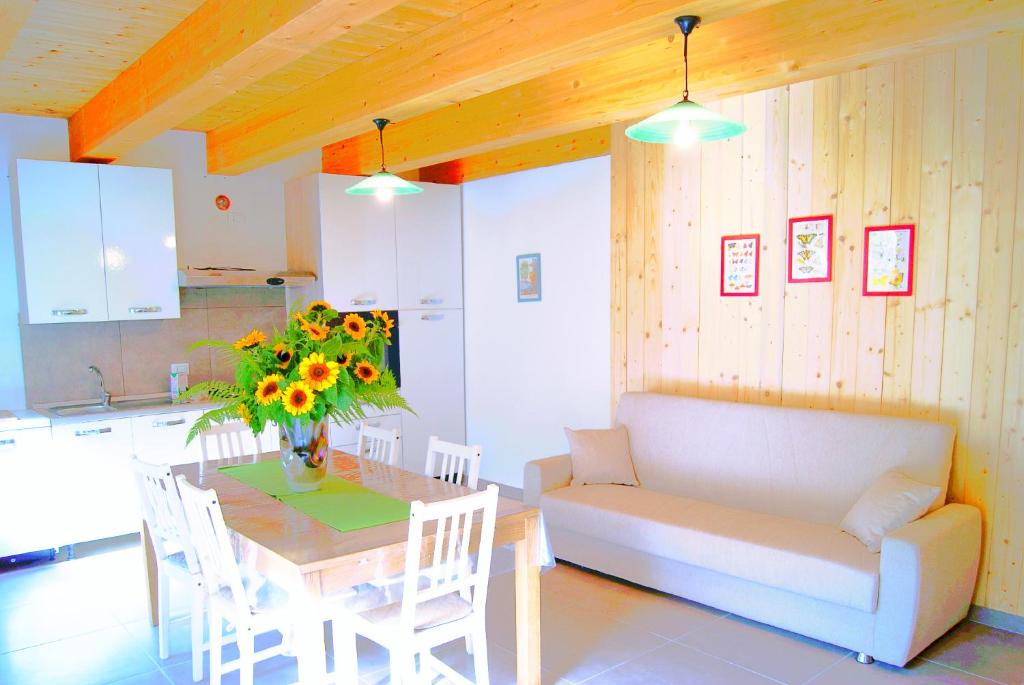 sala de estar con sofá y mesa con un jarrón de flores en Casa Speronella, en San Severino Lucano
